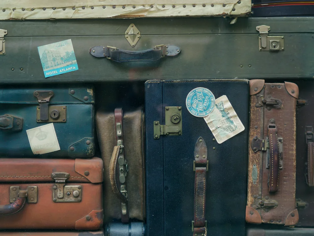 A neatly arranged stack of travel suitcases and bags