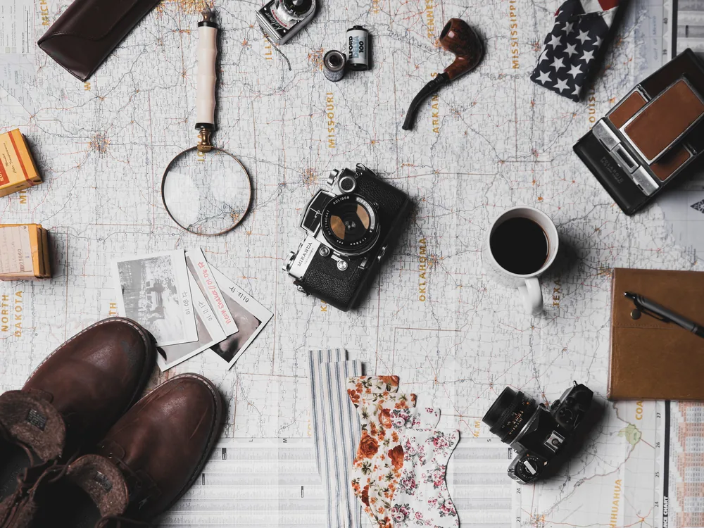 A traveler planning a trip with a map and notes spread out on a table